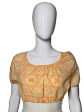 Load image into Gallery viewer, A short-sleeve blouse with an orange floral pattern, displayed on a white mannequin.