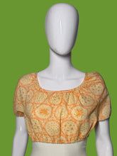 Load image into Gallery viewer, A short-sleeve blouse with an orange floral pattern, displayed on a white mannequin.