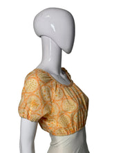 Load image into Gallery viewer, A short-sleeve blouse with an orange floral pattern, displayed on a white mannequin.