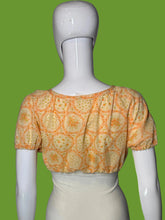 Load image into Gallery viewer, A short-sleeve blouse with an orange floral pattern, displayed on a white mannequin.