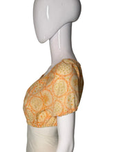 Load image into Gallery viewer, A short-sleeve blouse with an orange floral pattern, displayed on a white mannequin.