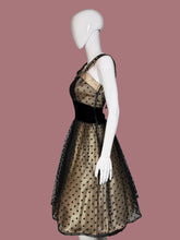 Load image into Gallery viewer, Mannequin wearing a black dress with gold polka dots on a white surface.
