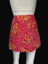 Load image into Gallery viewer, A red and orange patterned mini skirt with butterfly and polka dot motifs, displayed on a white mannequin.