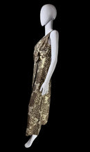 Load image into Gallery viewer, A mannequin wearing a sleeveless patterned dress with a brown and beige floral print.