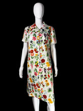 Load image into Gallery viewer, A white dress with a dense multicolor floral print, displayed on a white mannequin.