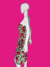 Load image into Gallery viewer, A white mannequin wearing a short floral dress with a red, green, and black animal-print pattern.