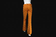 Load image into Gallery viewer, Orange and yellow patterned flared pants displayed on a white mannequin from the back.