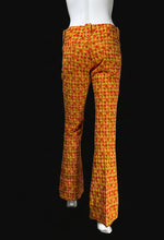 Load image into Gallery viewer, Orange and yellow patterned flared pants displayed on a white mannequin from the back.