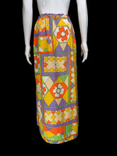 Load image into Gallery viewer, A mannequin wearing a long skirt with a bold geometric and floral pattern in yellow, orange, purple, green, and cream.