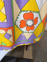 Load image into Gallery viewer, A close-up of a colorful patterned fabric with geometric shapes and floral motifs in yellow, orange, green, purple, and white. Photo displays some discoloration in the fabric near the hem.