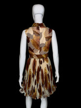 Load image into Gallery viewer, A sleeveless fit-and-flare dress displayed on a white mannequin. The dress features a brown and beige abstract leaf print on a sheer mesh fabric, with a matching waist sash and bow detail on the front.