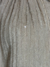Load image into Gallery viewer, A close-up of a ribbed knit fabric in a light taupe or beige-gray color, showing the texture and a small snag in the material.