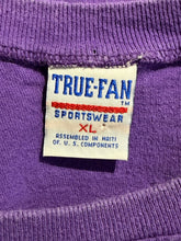 Load image into Gallery viewer, Close-up of a purple knit garment showing the inside neck label which reads TRUE-FAN SPORTSWEAR XL.