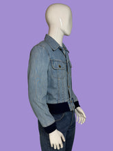 Load image into Gallery viewer, A light blue denim jacket with dark navy ribbed trim at the collar, cuffs, and hem, displayed on a white mannequin.