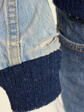 Load image into Gallery viewer, Close-up of a light blue denim jacket with a dark navy ribbed knit cuff, showing the texture and stitching details.