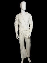 Load image into Gallery viewer, A white mannequin wearing a matching off-white military-style top and trousers set,