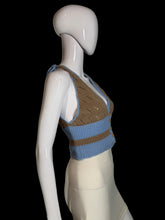 Load image into Gallery viewer, A sleeveless knit cardigan top displayed on a white mannequin. The top features a color block brown light blue knit with a button closure.