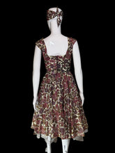 Load image into Gallery viewer, A sleeveless fit-and-flare dress with a bow headband, both in a brown, burgundy, and beige floral pattern, displayed on a white mannequin.