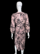 Load image into Gallery viewer, A pink long-sleeve midi dress with a black floral print, displayed on a white mannequin.