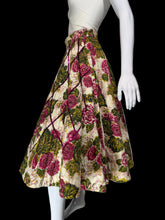 Load image into Gallery viewer, A vintage-style A-line skirt with a large floral print, displayed on a white mannequin. The skirt features a cream background with prominent pink and red roses and green leaves, accented by thin dark red stripes.