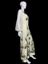 Load image into Gallery viewer, A cream-colored jumpsuit with a brown and gold paisley pattern and sheer white balloon sleeves, displayed on a white mannequin.