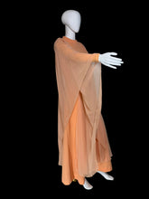 Load image into Gallery viewer, An orange vintage maxi dress with sheer draping sleeves displayed on a white mannequin, showing the arm out to highlight the long sheer material on the sleeve.