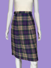 Load image into Gallery viewer, A plaid knee-length skirt displayed on a white mannequin. The skirt features a plaid pattern in purple, green, and beige with thin white lines.