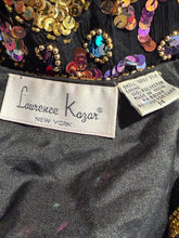 Load image into Gallery viewer, Close-up of the inside neck area of a black sequined garment by Lawrence Kazar, showing the brand label and a material tag.