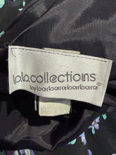 Load image into Gallery viewer, Close-up of a garment label reading 'b.b.collections by barbara barbara' sewn onto black fabric with a subtle floral print.