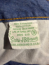 Load image into Gallery viewer, Close-up of a vintage Sears, Roebuck cotton garment label sewn inside a blue denim garment, showing text including '100% COTTON', 'MADE IN HONG KONG', and 'SEARS, ROEBUCK AND CO. U.