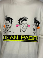 Load image into Gallery viewer, A close-up of a white graphic t-shirt featuring three stylized punk characters above a black and neon yellow 'OCEAN PACIFIC' banner.