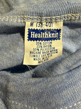 Load image into Gallery viewer, Close-up of a vintage Healthknit garment label sewn onto blue denim fabric, showing size M (38-40) and material composition details.