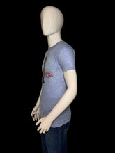 Load image into Gallery viewer, A mannequin wearing a faded light blue graphic t-shirt with a black and red 'The 1982 World's Fair' print