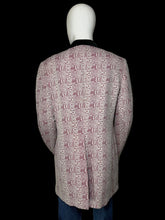 Load image into Gallery viewer, A men's patterned blazer jacket displayed on a white mannequin torso, viewed from the back. The jacket features a dusty pink and white monogram pattern with a solid black collar.