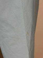 Load image into Gallery viewer, A close-up of a light blue textured fabric surface with a small brownish stain or mark near the center.