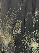 Load image into Gallery viewer, Close-up of a sheer black fabric with metallic gold floral embroidery and sequined detailing.
