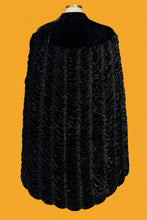 Load image into Gallery viewer, A black textured velvet cape jacket with a ruffled scalloped hem, displayed on a white mannequin shown from the back.