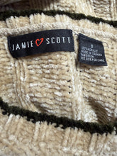 Load image into Gallery viewer, Close-up of a textured knit garment label reading JAMIE SCOTT with a red heart logo, alongside a size and material tag, on a cream and dark green striped knit fabric.