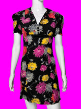 Load image into Gallery viewer, A short-sleeve black dress with a colorful floral print, displayed on a white mannequin.