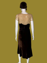 Load image into Gallery viewer, A dark brown velvet 1920s midi length dress displayed on a white mannequin. The set includes a matching brown head covering.