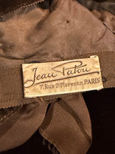 Load image into Gallery viewer, Fabric tag on brown garment reading "Jeau Patou" and "7 Rue St Forentin, PARIS"