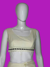 Load image into Gallery viewer, A cream-colored sleeveless crop top with a scoop neckline and a decorative black lace trim band, displayed on a white mannequin torso.