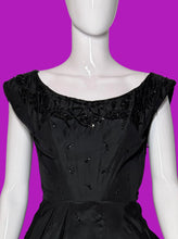 Load image into Gallery viewer, A black sleeveless fit-and-flare dress with cap sleeves, a scoop neckline, and ornate lace and bead trim details, displayed on a white mannequin.