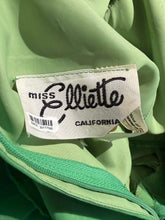 Load image into Gallery viewer, Close-up of a light green garment's interior label reading 'miss Elliette CALIFORNIA' on a white fabric tag.