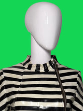 Load image into Gallery viewer, Close up of horizontal black and white striped garment with metal O ring zipper.