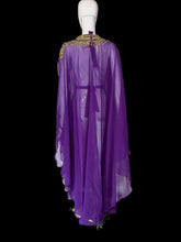 Load image into Gallery viewer, A purple sheer maxi dress with a high embroidered neckline and long draped sleeves, displayed on a white mannequin.