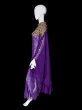 Load image into Gallery viewer, A purple sheer maxi dress with a high embroidered neckline and long draped sleeves, displayed on a white mannequin.
