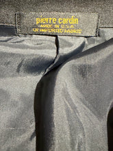 Load image into Gallery viewer, Close-up of a garment's inner neck label reading 'pierre cardin' in yellow text on a dark gray satin-like fabric.