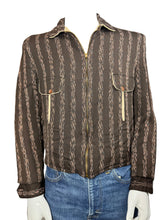 Load image into Gallery viewer, Brown patterned jacket on a white surface with blue jeans partially visible