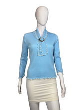 Load image into Gallery viewer, Mannequin wearing a light blue top with lettuce hem details and a beige skirt against a plain background